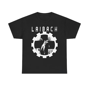 May include: Black t-shirt with the word "LAIBACH" in white block letters above a white graphic. The graphic is a gear-shaped design with a cross and a figure inside. The shirt is made of a soft material.