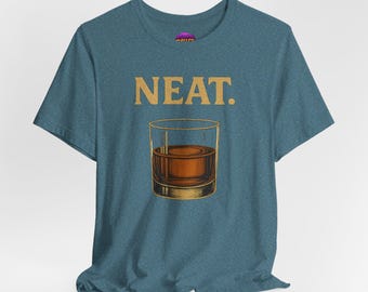 Könnte beinhalten: Blaugrünes T-Shirt mit dem Wort "NEAT." in goldfarbenen Buchstaben über einer Grafik eines Whiskeyglases, das mit bernsteinfarbener Flüssigkeit gefüllt ist. Das Shirt ist aus einem weichen Material.