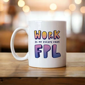 Könnte beinhalten: Weiße Keramik-Tasse mit dem Text "WORK IS MY ESCAPE FROM FPL" in bunten Buchstaben. Die Tasse hat einen Standardgriff und steht auf einer Holzoberfläche.