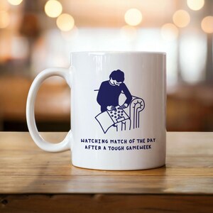 Könnte beinhalten: Ein Set aus drei Keramikbechern mit gesprenkelter, matter Oberfläche. Die Becher sind in Creme-, Hellgrau- und Dunkelgrautönen gehalten. Jeder Becher hat ein schlichtes, minimalistisches Design.