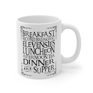 Peut inclure: Une tasse en céramique blanche avec du texte noir qui dit "Breakfast, Second Breakfast, Elevensies, Luncheon, Afternoon Tea, Dinner and Supper, The Hobbit Diet".