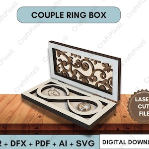Könnte beinhalten: Eine weiße und braune Holz-Paar-Ringbox mit einem Unendlichkeits-Symbol-Design. Die Box ist geöffnet und zeigt zwei Ringhalter. Die Oberseite der Box hat ein dekoratives Blumenmuster. Auf der Box steht "COUPLE RING BOX" und "LASER CUT FILE".