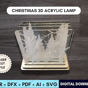 Puede incluir: Una lámpara navideña de acrílico transparente con una escena de bosque invernal grabada en los paneles. La lámpara se asienta sobre una base de madera y presenta el texto "CHRISTMAS 3D ACRYLIC LAMP". Incluye el texto "LASER CUT FILE" y "DIGITAL DOWNLOAD".