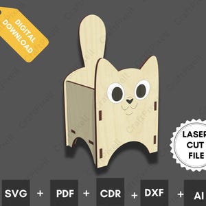Op de afbeelding: Een houten katvormige organizer met een staart, ogen en een lachend gezicht. Het ontwerp bevat sleuven voor montage. Een geel label leest "DIGITALE DOWNLOAD". De tekst "LASER CUT FILE" en bestandstype-pictogrammen zijn ook aanwezig.