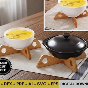 Peut inclure: Des dessous de plat en bois soutenant un bol blanc de soupe et une marmite noire. Les dessous de plat ont un design en forme de croix avec des découpes circulaires. Le texte "LASER CUT FILE" et "DIGITAL DOWNLOAD" est également inclus.