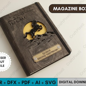 以下が含まれることがあります： 暗い木製のマガジンボックス。レーザーカットされたデザインで、黄色い背景に山を飛び越える馬が描かれています。ボックスにはロシア語のテキストとネームプレートがあります。「MAGAZINE BOX」の文字が上部に表示されています。