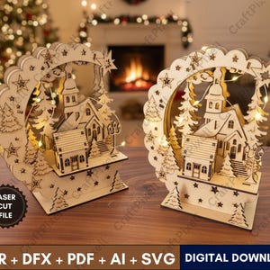 Puede incluir: Dos decoraciones de pueblo navideño de madera cortadas con láser. Cada una presenta una iglesia, árboles y un arco salpicado de estrellas. Las bases son rectangulares y los diseños están iluminados con luces de hadas. El texto "LASER CUT FILE" es visible.