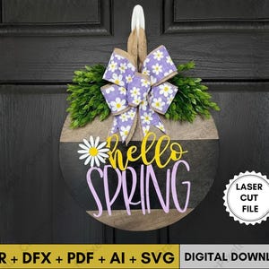Puede incluir: Colgador de puerta redondo de madera con un diseño a rayas negras y marrones. Cuenta con un lazo morado con detalles de margaritas blancas, follaje verde y las palabras "hello SPRING" en amarillo y morado. Incluye el texto "LASER CUT FILE".
