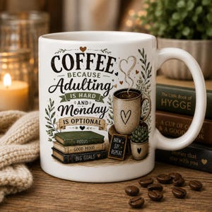 May include: A white ceramic mug featuring the text COFFEE BECAUSE Adulting IS HARD AND Monday IS OPTIONAL. The design includes a stack of three books labeled FOCUS, GOOD MOOD, and BIG GOALS, a small potted succulent, and a steaming cup of coffee.