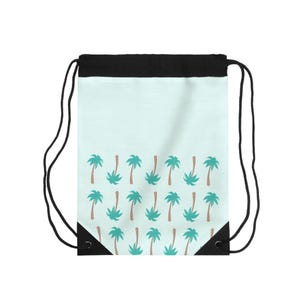 May include: A drawstring backpack with a light blue background and a repeating pattern of teal palm trees with brown trunks. The top of the bag is black, and it has black drawstring cords.
