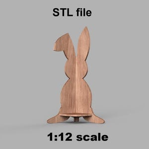 May include: A wooden bunny-shaped shelf, with the text "STL file" above and "1:12 scale" below. The shelf is light brown and has a small shelf area. The bunny has long ears and is standing upright.