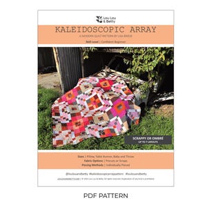 May include: A PDF quilt pattern titled KALEIDOSCOPIC ARRAY by Lou Lou & Betty. The cover features a colorful quilt with pink, orange, and brown geometric blocks. Text includes Skill Level: Confident Beginner, Scrappy or Ombré, and sizes for Pillow, Table Runner, Baby and Throw. The design is shown draped over a vehicle.