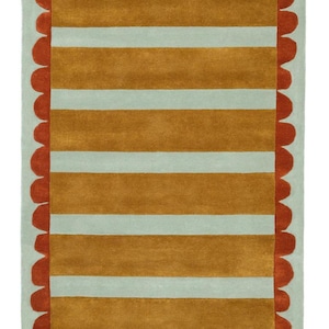 May include: A rectangular rug with a pale blue background, featuring horizontal stripes in shades of gold and white. The rug has a scalloped border in a reddish-orange colour, adding a decorative touch to the design.