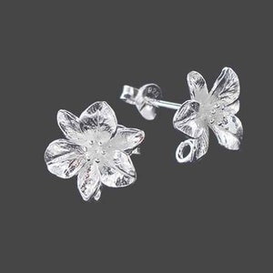 Op de afbeelding: Een paar zilveren bloem oorbel studs. De bloemen zijn gedetailleerd en hebben een delicaat ontwerp.