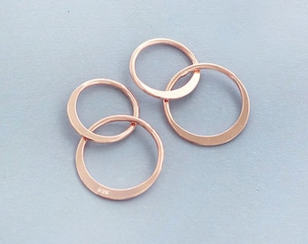 May include: A pair of rose gold hoop earrings with a double circle design. The earrings are made of a thin metal and have a simple, elegant style.