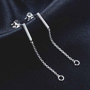 May include: A pair of silver dangle earrings with a small bar and a chain that ends with a small circle.
