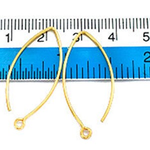 May include: Two gold-colored earring hooks, each measuring approximately 2 inches in length, are displayed against a blue ruler.