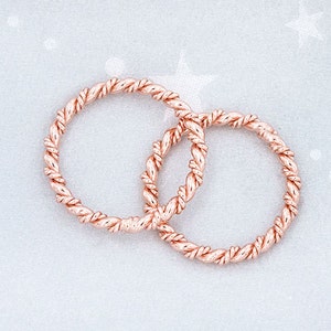 May include: Two rose gold rings with a twisted rope design.