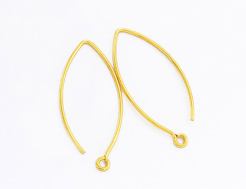May include: A pair of gold-toned earring hooks. The hooks are made of metal and have a simple, elegant design.