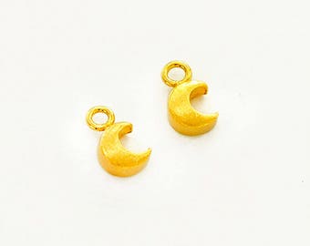 May include: Two gold-colored crescent moon charms with a loop at the top for attaching to jewelry or other crafts.