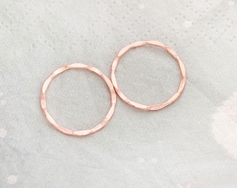 May include: Two rose gold hammered metal rings. The rings are simple and delicate, perfect for layering or wearing alone.