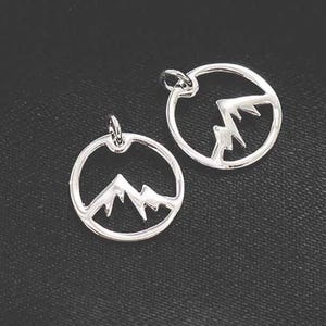 May include: Two silver charm pendants featuring a mountain range design. The pendants are circular and have a smooth, polished finish.
