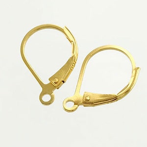 May include: Two gold-colored leverback earring findings. Each finding has a curved, teardrop-shaped wire loop and a hinged lever closure. The findings are designed for attaching to earring components.