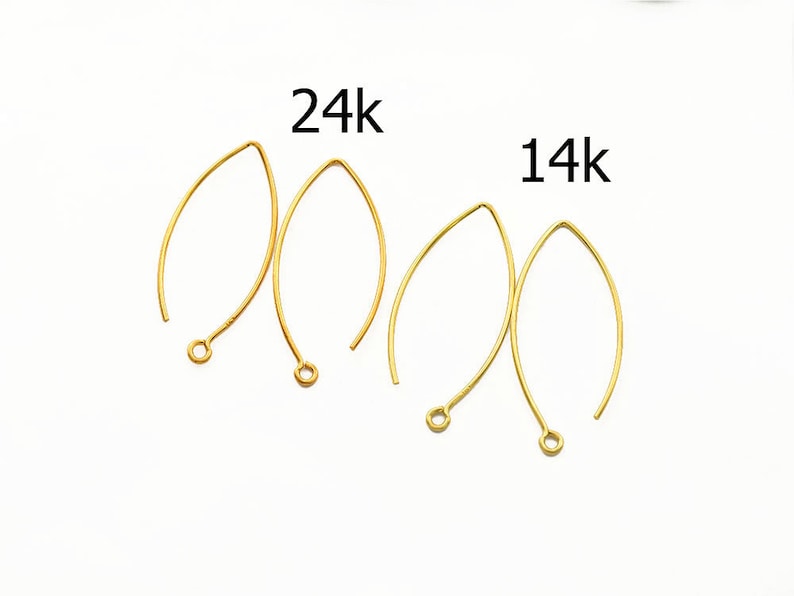 May include: Two pairs of gold earring wires, one pair labeled "24k" and the other labeled "14k".