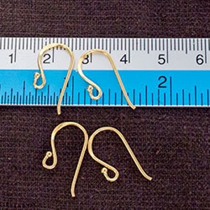 Op de afbeelding: Vier goudkleurige metalen oorbelhaakjes met een gebogen draadontwerp en een klein lusje aan de onderkant. Een liniaal is boven de bovenste twee haakjes geplaatst, wat een breedte van ongeveer 2 cm per individueel oorbelhaakje aangeeft.