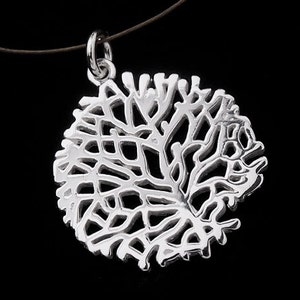 Op de afbeelding: Een zilveren ketting met een hanger met een delicaat, ingewikkeld ontwerp van een boom met takken die zich in een cirkelvorm uitspreiden.