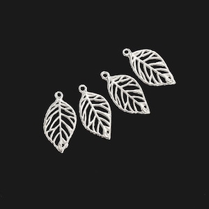 Op de afbeelding: Vier zilveren blaadjes met een gaatje bovenaan om aan sieraden of andere knutselwerkjes te bevestigen.