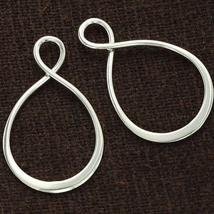 Peut inclure: Deux boucles d'oreilles en métal argenté avec un design torsadé. Les boucles sont de forme ovale et ont une finition lisse.