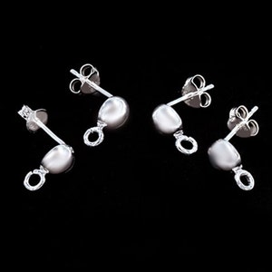 May include: Four silver earring findings with a loop at the bottom. The findings have a small ball at the top and a post with a butterfly back.