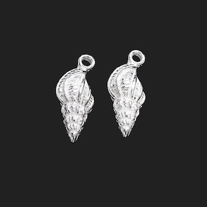 May include: Two silver-toned seashell charms with a loop at the top for attaching to jewelry or other crafts.