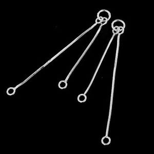 May include: Four silver jump rings with a loop at each end. The jump rings are connected to each other by the loops.