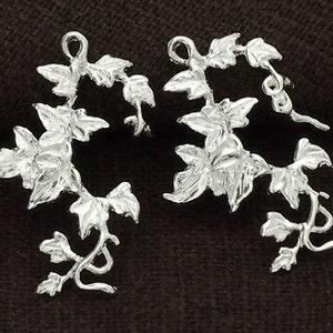 Op de afbeelding: Twee zilveren klimop-rank charms met een lus aan de bovenkant om te bevestigen aan sieraden of andere knutselwerkjes.
