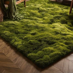May include: A large, rectangular green rug with a textured, moss-like appearance. The rug is a vibrant shade of green and covers a significant portion of the floor. The rug is placed on a wooden floor with a herringbone pattern.