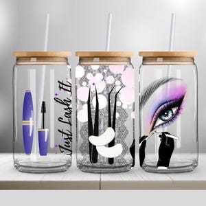 Könnte beinhalten: Drei transparente Glasbecher mit Bambusdeckeln und weißen Strohhalmen. Jeder Becher hat ein anderes Design, das sich auf Wimpern bezieht. Einer hat einen lila Mascara und Applikator, ein anderer Wimpernwerkzeuge und der letzte ein detailliertes Auge mit Make-up.