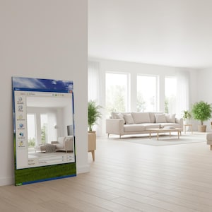 May include: A rectangular wall art piece leaning against a white wall. The art features a Windows XP interface with a reflected image of a modern living room with a beige sofa, wooden coffee table, and green plants.