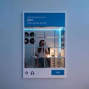 May include: A white framed mirror with a grid of squares, reflecting a room with a desk, records, and a person wearing headphones. The top section has blue text that reads "Select all squares that show you. If there are none, click skip." The bottom has a skip button.
