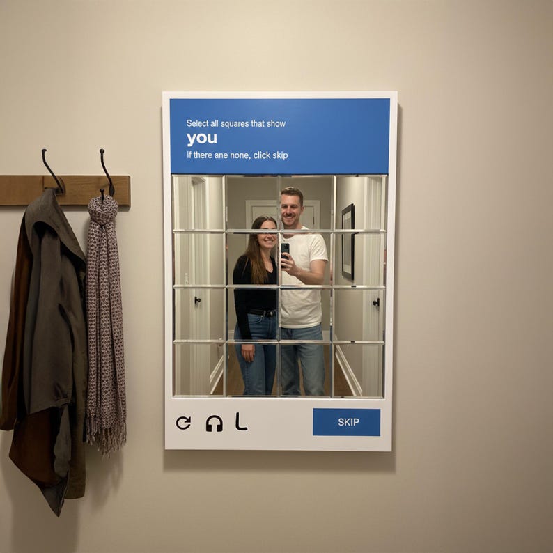 May include: A white framed mirror with a grid pattern, reflecting a couple taking a photo. The top section has blue text that reads "Select all squares that show you". The bottom has the word "SKIP" in a blue box.