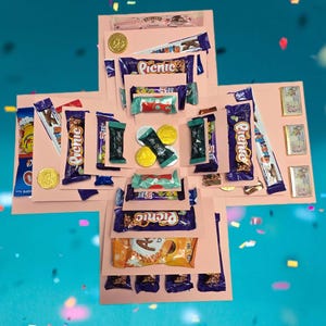 May include: A pink cardboard gift box unfolded into a cross shape, filled with an assortment of chocolate bars, including Picnic, Aero, and After Eight, along with gold and silver foil-wrapped chocolate coins and small rectangular chocolate squares.