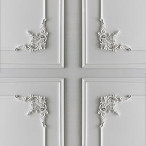 May include: White wall panelling with symmetrical floral corner designs. The panelling features a grid pattern with vertical and horizontal lines, creating a classic, decorative aesthetic. The floral designs add a touch of elegance.