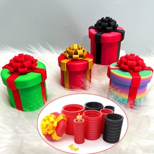 May include: A collection of colorful, cylindrical gift boxes with decorative bows. The boxes are red, green, and rainbow-colored, with matching or contrasting ribbons and bows. A smaller inset shows the disassembled components.