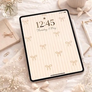 Può includere: Un tablet digitale mostra uno sfondo color crema con strisce verticali e motivi a fiocco. Lo schermo mostra l'ora 12:45 e la data giovedì 8 maggio. Sono visibili anche una tazza di caffè, fiori e un quaderno.