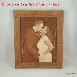 Pode incluir: Uma fotografia emoldurada de um casal se beijando, gravada em um fundo de couro marrom. A moldura &eacute; de madeira com acabamento r&uacute;stico.