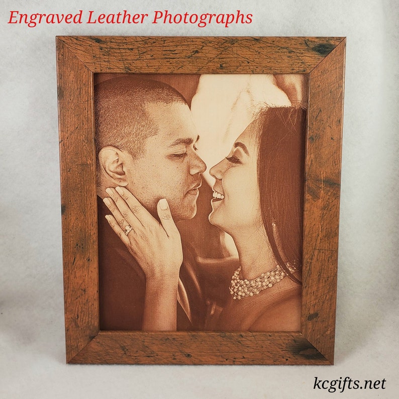 Pode incluir: Uma fotografia emoldurada de um casal se beijando, gravada em um fundo de couro marrom. A moldura &eacute; feita de madeira r&uacute;stica com uma mancha marrom.