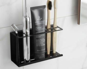 Organizador moderno de pared para cepillos de dientes y baño con diseño metálico.