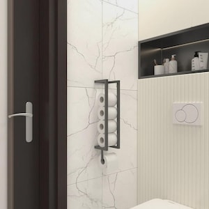May include: A modern, matte black metal toilet paper holder mounted on a marble-patterned tile wall. The holder is rectangular and holds six rolls of white toilet paper. The bathroom setting includes a dark door and a recessed shelf.