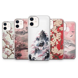 May include: Five phone cases with Japanese-style art. Designs include cherry blossom branches, mountain scenes, and temples. The cases display pink, red, and white colour schemes, with detailed illustrations of landscapes and nature.